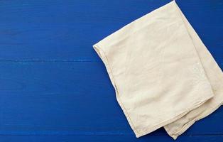 toalla textil de cocina blanca doblada sobre una mesa de madera azul de tablas antiguas foto