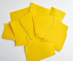 pila de papel amarillo pedazos de papel rotos sobre un fondo blanco foto