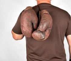 atleta masculino sostiene un par de guantes de boxeo antiguos muy antiguos