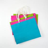 Bolsas de compras rectangulares de papel multicolor con asas. foto