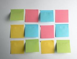pink, blue, green paper stickers pasted on white  background photo