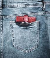 leather purse lies in the back pocket of blue jeans photo