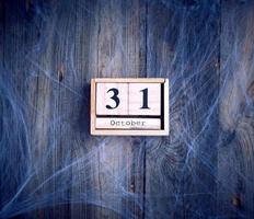 White spider web and wooden retro calendar made of blocks with the date of October 31 photo