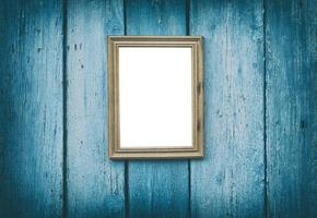 empty wooden frame hanging on blue cracked wooden wall photo