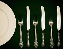 Half empty white plates, vintage knife and fork photo