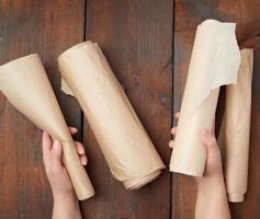 four rolled rolls of brown parchment paper on a wooden surface photo