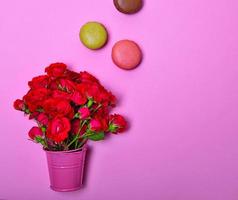 Bouquet of pink roses and multicolored macaroons photo