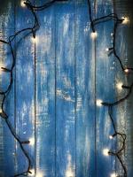 Electric garland with small paws on a blue wooden background photo