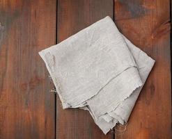 gray linen towel on wooden background, top view photo