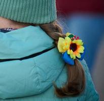 Braided hair of a girl with a yellow-blue bow photo