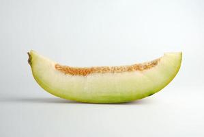 piece of ripe melon with seeds on a white background photo