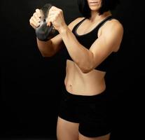 young woman of Caucasian appearance holds steel dumbbell in her hand photo