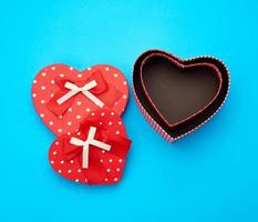 open empty red cardboard box in the form of a heart on a light blue background photo