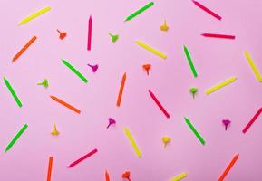 colorful wax holiday candles on a pink background photo