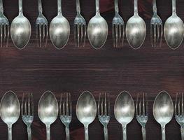 Wooden background with vintage spoons and forks photo