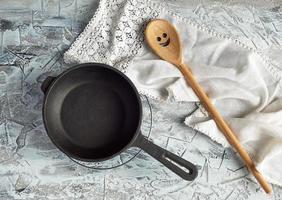 empty black round frying pan with handle and spoon photo