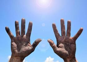 Male hands smeared with mud and raised up photo