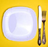 empty white square plate and metal fork and knife photo