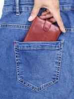 leather purse in the back pocket of blue jeans photo