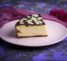 trozos de tarta de queso con chocolate en un plato rosa foto