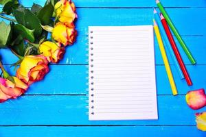 Blank notepad with colored pencils photo