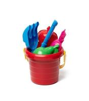 baby red plastic bucket with shovel and toys isolated on white background. Outdoor items