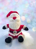 Textile Santa Claus sitting on a snow bank photo