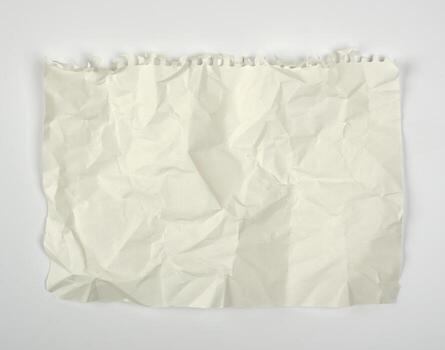crumpled blank white rectangular sheet of paper torn out of a spiral notebook photo