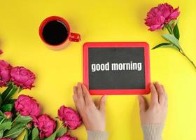 two female hands are holding a black chalk frame with the words good morning photo