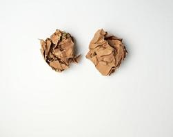 two crumpled sheets  of brown paper on a white background photo