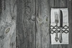 Cutlery knife and fork on gray wooden surface photo