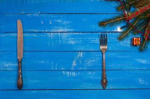 Silver knife and fork on a blue wooden background photo