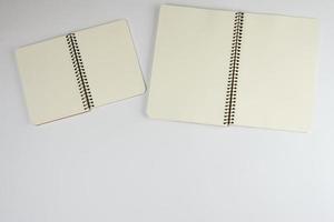 two open spiral notepad with empty white sheets photo