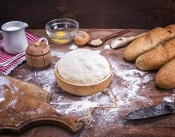 masa de levadura de trigo para pan y panecillos en un bol de madera foto