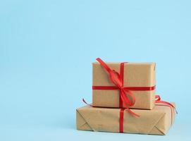 stack of boxes wrapped in brown paper and tied with a red bow photo