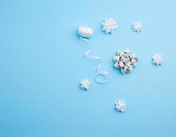 knitted white bows and white ribbon on a blue background photo