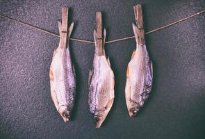 Three dried flaxes are attached with clothespins on a rope photo