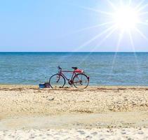 vieja bicicleta roja junto al mar foto