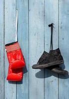 Black textile worn sneakers and red leather boxing gloves photo