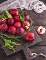 red ripe peaches nectarine in an iron plate photo