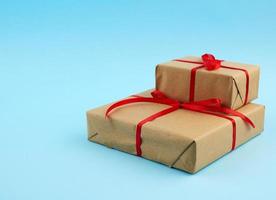 stack of boxes wrapped in brown paper and tied with a red bow photo