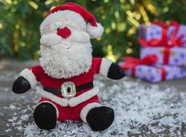 Santa Claus on a gray wooden surface with snow photo
