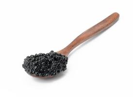 caviar de pez espátula negro granulado fresco en una cuchara de madera marrón sobre fondo blanco foto