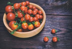Ripe red cherry tomatoes in a wooden bowl