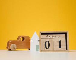 Wooden calendar made of cubes on a yellow background. Date January 1st, beginning of the year photo