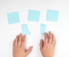lot of blue stickers on a white background and two female hands photo