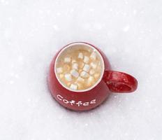 taza roja con café caliente y malvavisco foto