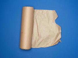 roll of brown parchment paper on a blue background, copy space photo