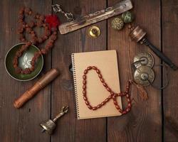 Copper singing bowl, prayer beads, prayer drum and other Tibetan religious objects for meditation photo