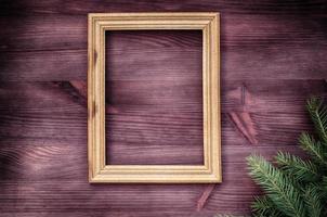 Empty wooden frame with a branch of spruce in the corner photo